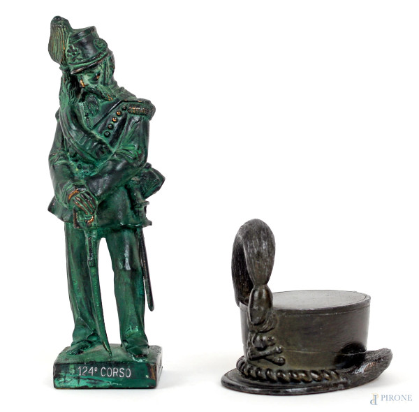 Lotto di due oggetti in bronzo e metallo raffiguranti artigliere ed un cappello con piuma, alt. max cm 16,5, XX secolo.