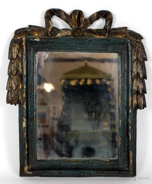 Specchiera del XVIII secolo, in legno intagliato, laccato e dorato, cimasa a fiocco da cui si dipartono ghirlande, ingombro cm. 32x28, luce cm. 21,5x17