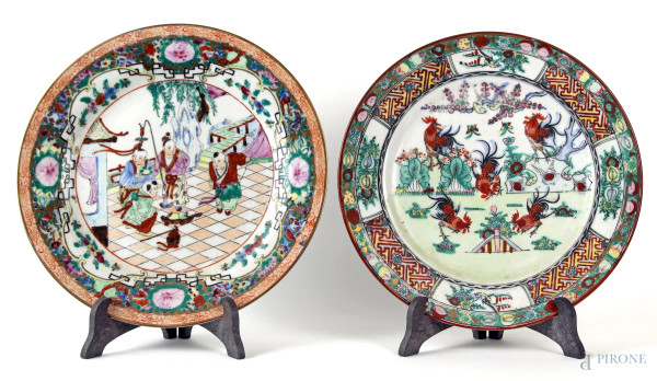 Lotto composto da  due piatti in porcellana policroma raffiguranti galli e scena di corte, diam. max cm 27,5, Cina, XX secolo, (piccoli difetti).