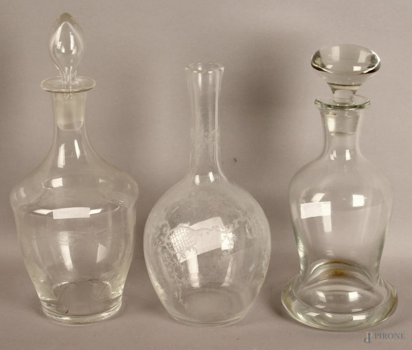 Lotto composto da tre bottiglie diverse in cristallo, altezza 30 cm.