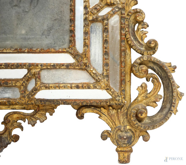 Specchiera a doppio ordine con cornice decorata da specchi incisi, cimasa sagomata a volute contr...