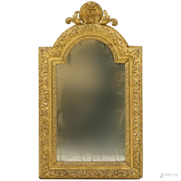 Specchiera centinata del XIX secolo, in legno intagliato e dorato, cornice percorsa da decoro naturalistico, cimasa floreale, misure ingombro cm 79x45, (difetti e restauro)