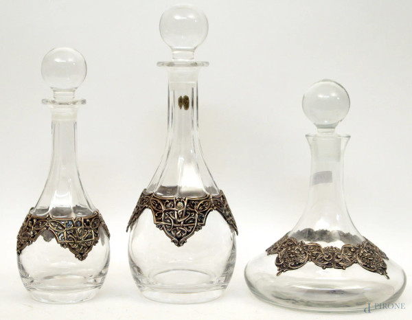 Lotto composto da due bottiglie e un decanter in vetro, fasce in argento cesellato, H massima 33 cm.