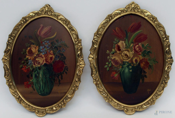 Coppia di dipinti ad assetto ovale a soggetto di nature morte, olio su cartone, entro cornici in ottone firmate, cm 19 x 14.