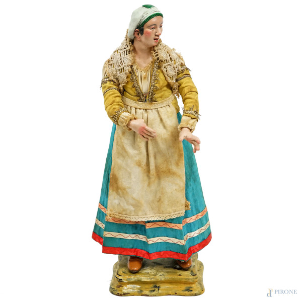 Contadina con scialle, scultura da presepe in legno scolpito e dipinto, testa modellata in terracotta, occhi in pasta di vetro, cm h 42, Napoli, XX secolo, poggiante su base in legno. Abiti in tessuti diversi, (difetti)