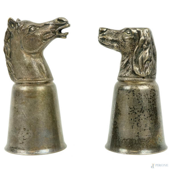 Due bicchieri in metallo argentato con teste animali, alt. max cm 15, (segni del tempo).