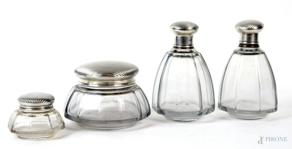 Servizio da toeletta, composto da quattro oggetti in vetro con tappi in argento, cm h 13, inizi XX secolo.