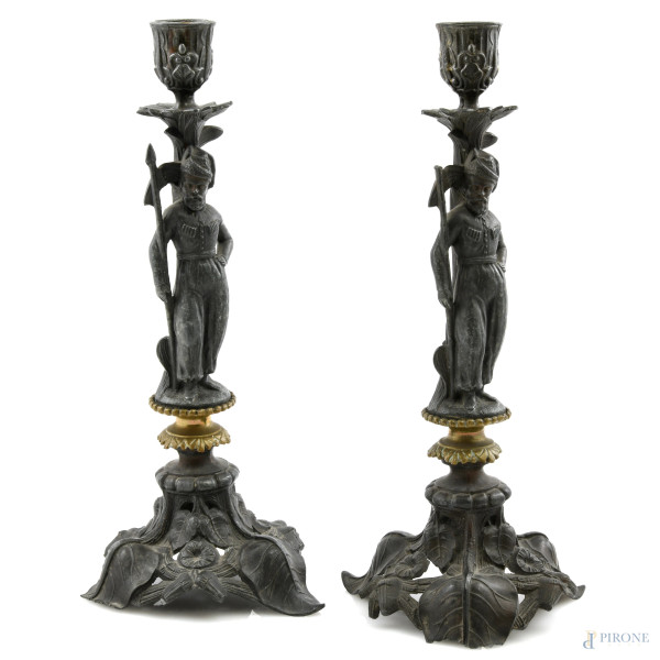 Coppia di candelieri in antimonio con decori a guisa di foglie e soldati, XX secolo, altezza cm 29, (segni di usura, difetti)