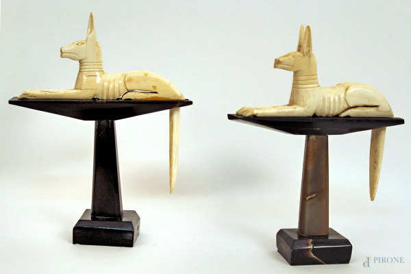 Coppia di alzatine in corno reggenti cani egizi in avorio, primi &#39;900, H 20 cm.
