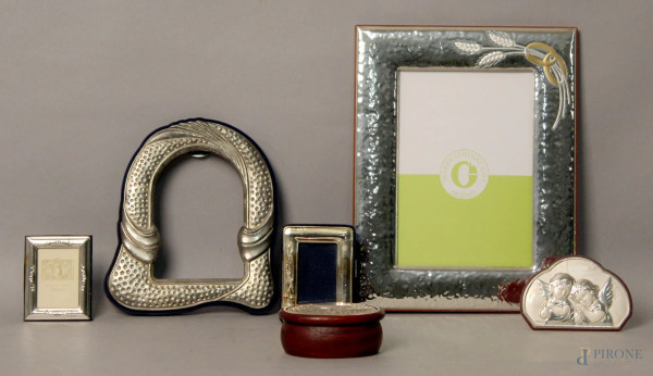 Lotto composto da quattro cornici portafoto, una scatolina ed una placchetta in argento e metallo, h. massima 25 cm.