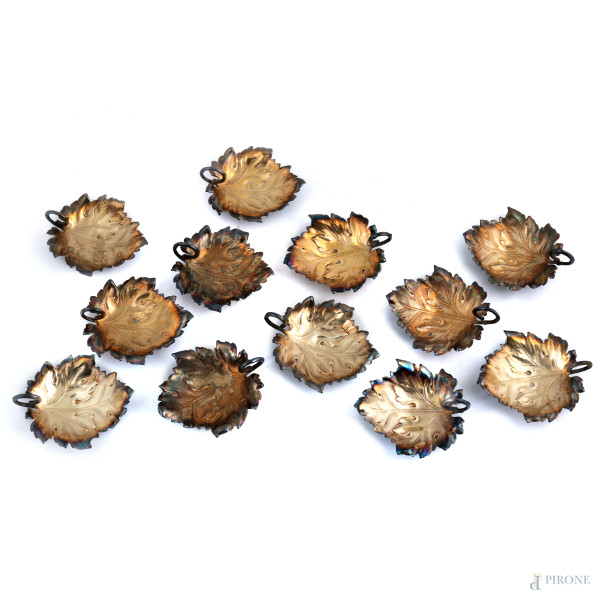 Lotto di 12 piatti in metallo a guisa di foglia, XX secolo, cm 12x10, (segni di usura)
