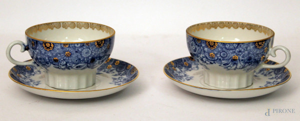 Coppia di tazze con piattino in porcellana a decori di fiori con particolari dorati, Russia primi 900.