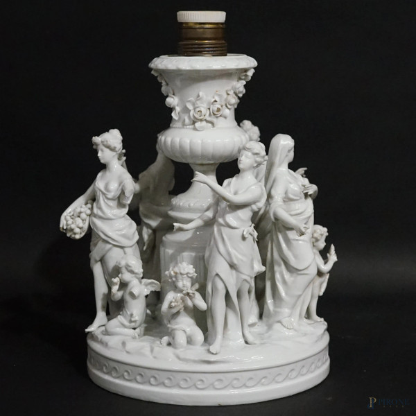 Lampada da tavolo in porcellana bianca, Germania, Volkstedt Rudolstadt, XIX secolo, decorata da cinque figure femminili e putti danzanti, cm h 28,5, (difetti)