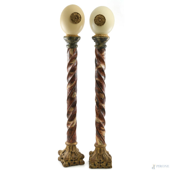 Coppia di colonne in legno dorato e dipinto a finto marmo con uova di struzzo apicali con inserti in metallo dorato, XX secolo, altezza massima cm 85, (lievi segni di usura, scalfiture)