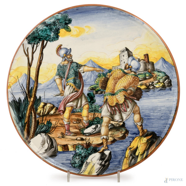 Piatto in ceramica dipinta con coppia di guerrieri, XX secolo, diametro cm 37, al fondo "G.B.T Made in Italy" (segni di usura, piccole cadute di smalto, difetti di cottura)