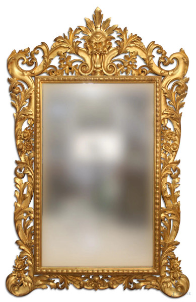 Splendida specchiera in legno dorato, con cornice finemente intagliata a foglie d&#39;acanto e fiori, angoli a riccioli, fregio superiore con mascherone, XIX sec., cm 230 x 148, piccoli restauri.