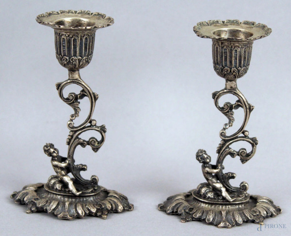 Coppia di candelieri ad una luce in argento cesellato, h cm 11,5 gr. 210.