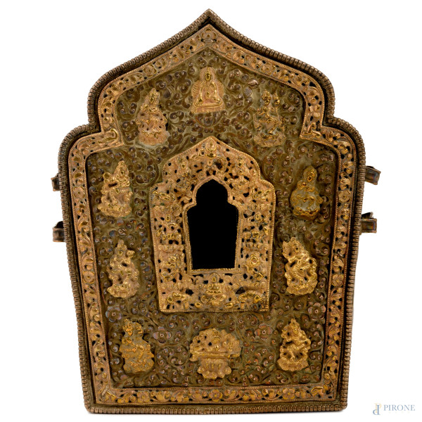 Ghau tibetano in metallo argentato e dorato riccamente decorato a motivi vegetali incisi e cesellati a rilievo con figure di divinità, (difetti), cm 20x15x7