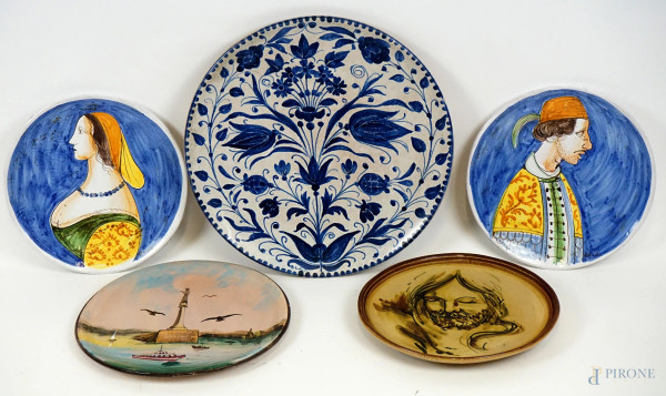 Lotto di cinque piatti in ceramica dipinta, decori raffiguranti soggetti diversi, diam max cm 42,5