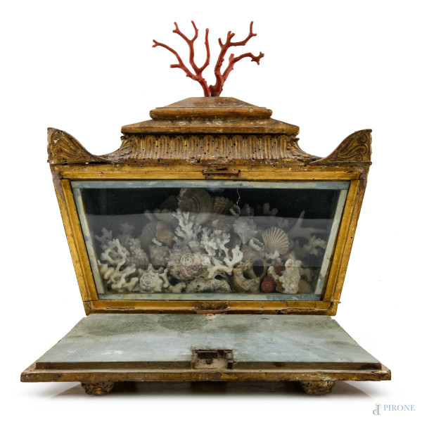 Elemento decorativo da tavolo in legno intagliato e dorato con sportello a ribalta celante teca con finti coralli e conchiglie, XX secolo, cm 37x34x16, (segni di usura, scalfiture, fori di tarlo, difetti, rotture)
