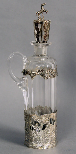Caraffa in cristallo con applicazioni in argento cesellato, h. 22 cm.