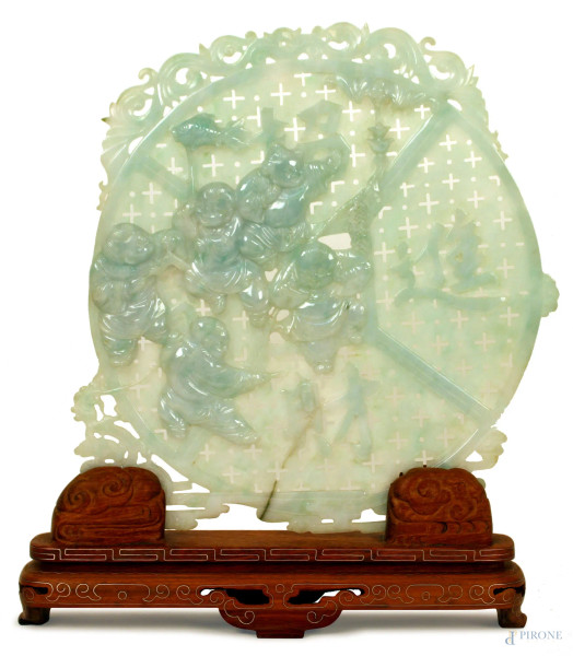 Placca tonda in giadeite traforata con bassorilievi raffiguranti fanciulli, base in legno, diametro 26 cm., Cina XX sec.