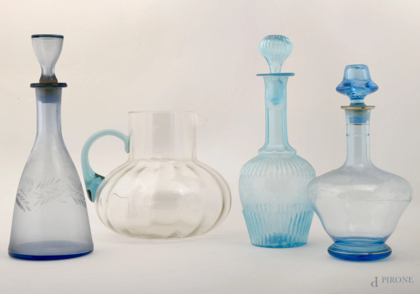 Lotto composta da una grande caraffa e tre bottiglie in vetro nei toni dell'azzurro, altezza max cm 33 (difetti)