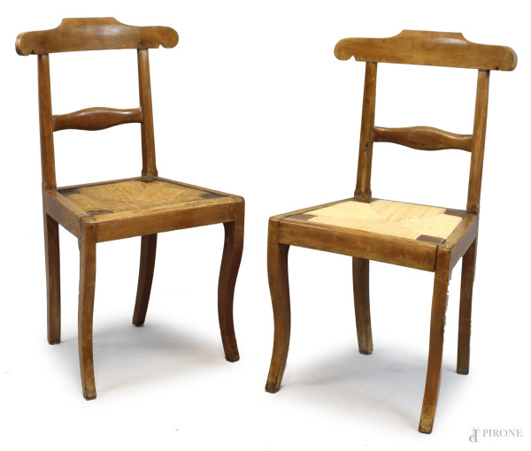 Coppia di sedie in noce, schienali a giorno, sedute in paglia, gambe mosse, inizi XX secolo, cm h 88
