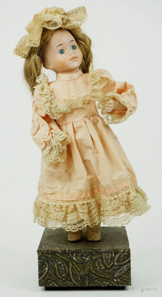 Bambola da collezione con carillon, veste e cappellino in stoffa e merletti, ingombro tot cm 47x15,5x15,5, inizi XX secolo, (difetti, carillon funzionante).
