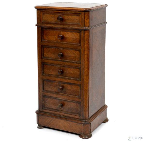 Comodino in noce ad un cassetto al fronte e cinque finti cassetti disposti a colonna su unico sportello. Interno a doppio ripiano, XX secolo, cm 85,5x41,5x36 (segni di usura)