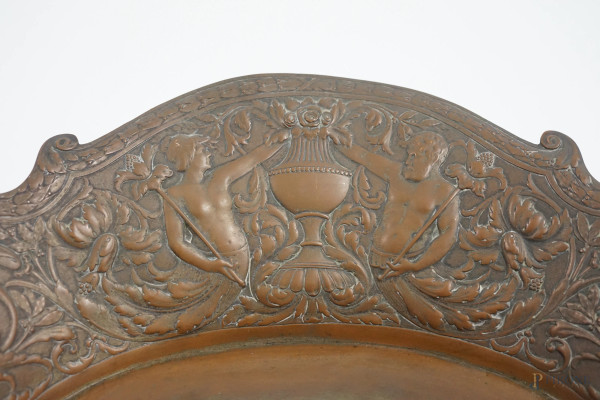 Lotto composto da un centro tavola ovale in metallo sbalzato con decori vegetali e figure e un va...