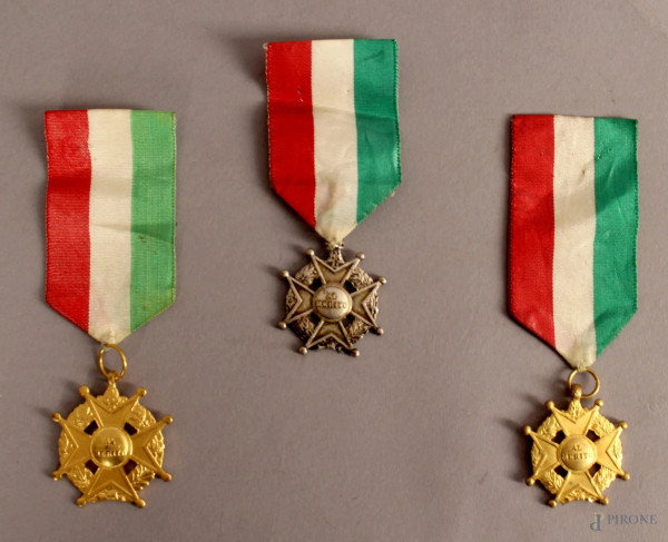 Lotto composto da tre medaglie al merito in metallo dorato e argentato.