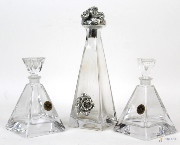 Lotto di tre bottiglie in cristallo, tappo ed applicazioni in resina argentata, alt. max cm 22, XX secolo, (difetti)