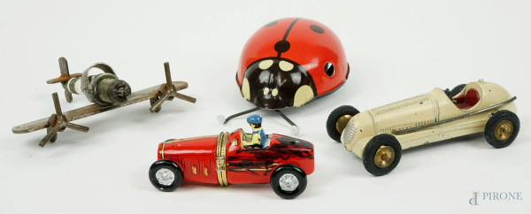 Lotto composto da un giocattolo a forma di coccinella e tre modellini di auto e aereo, materiali diversi, misure max cm 8x11, XX secolo, (difetti).