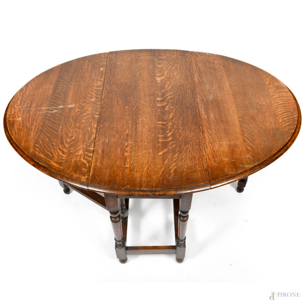 Tavolo ovale a bandelle in rovere con gambe tornite e raccordate, XX secolo, chiuso cm 72,5x102,5...