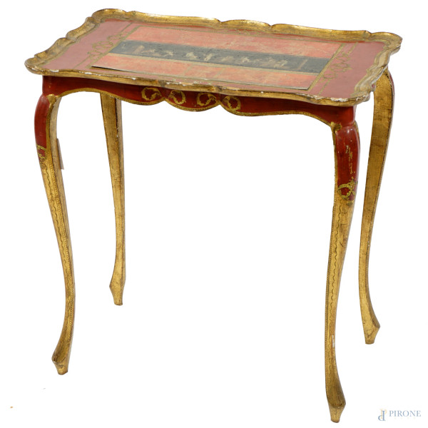 Tavolino in legno dorato e laccato rosso, prima metà XX secolo, piano sagomato con decoro di gusto pompeiano, quattro gambe mosse, cm h 50x43,5x34,5, (difetti).