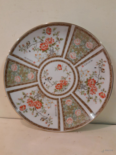 Piatto orientale in porcellana a decoro floreale marcato diam. 26 cm.