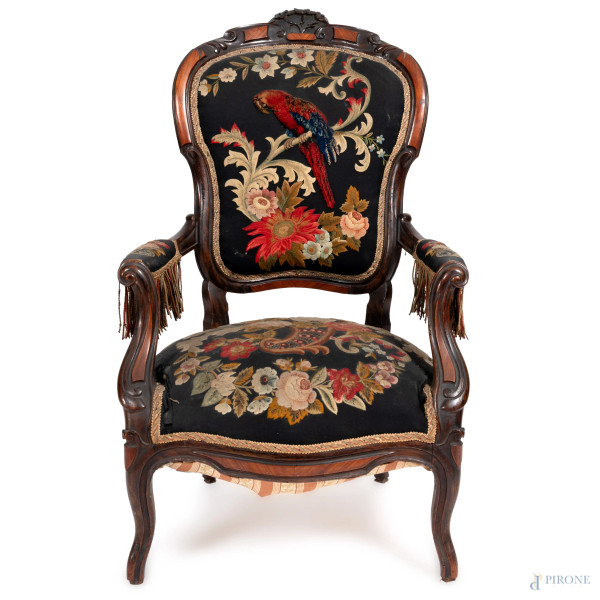 Poltrona in stile Luigi Filippo in legno intagliato con schienale, seduta e braccioli imbottiti e rivestiti in tessuto decorato a motivi floreali e pappagallo, XX secolo, cm 105x65x55 (segni di usura, scalfiture, rotture, difetti)
