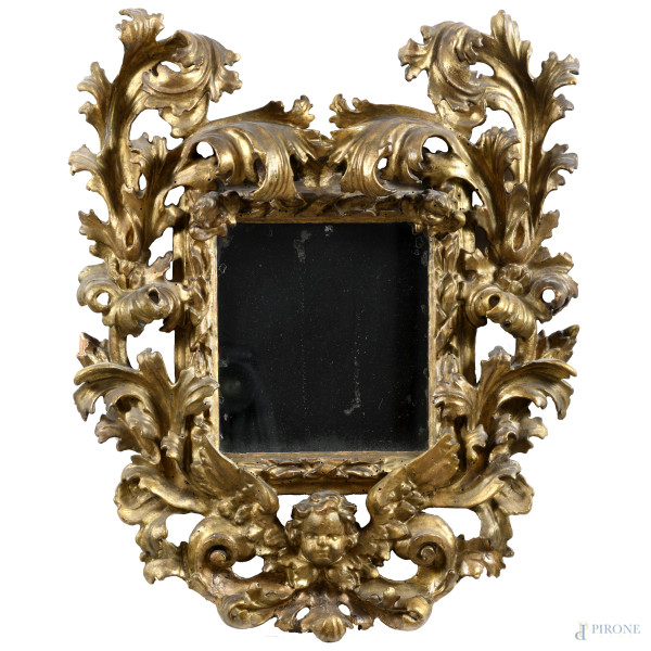 Cornice in legno dorato e finemente intagliato a girali e foglie d'acanto con elemento a testa di putto, XVIII-XIX secolo, cm 70x56; luce cm 25x23 (segni di usura, sbeccature, mancanze, rotture, fori di tarlo)