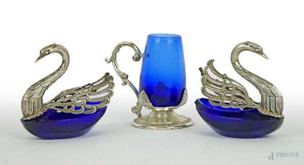 Lotto composto da coppia di saliere a forma di cigni ed un bicchierino in metallo argentato e vetro blu cobalto, alt. max cm 8, XX secolo