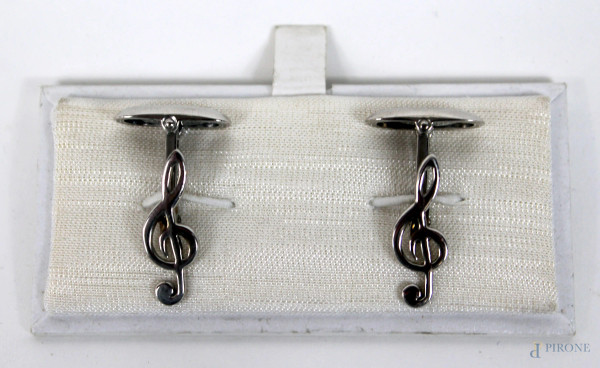 Lotto di due paia di gemelli in argento, a forma di chiave di violino e sassofoni.