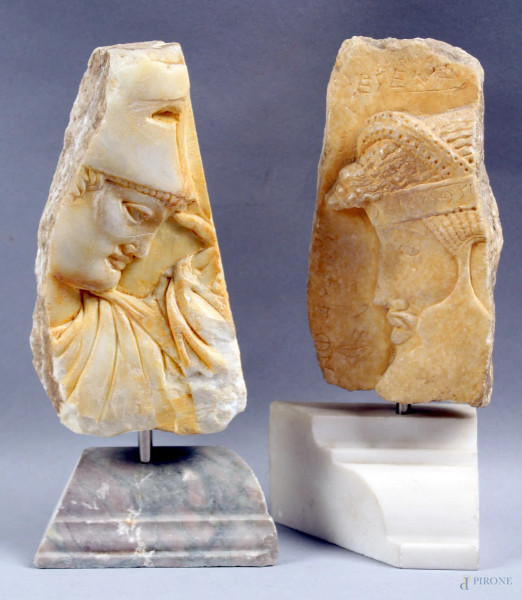 Lotto composto da riproduzioni di due frammenti in marmo scolpito a rilievo, raffiguranti profili, h. 16 cm, (senza base).