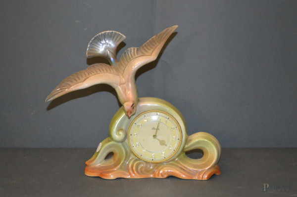 Orologio da tavolo in ceramica con volatile a rilievo, periodo liberty, h.25 cm.