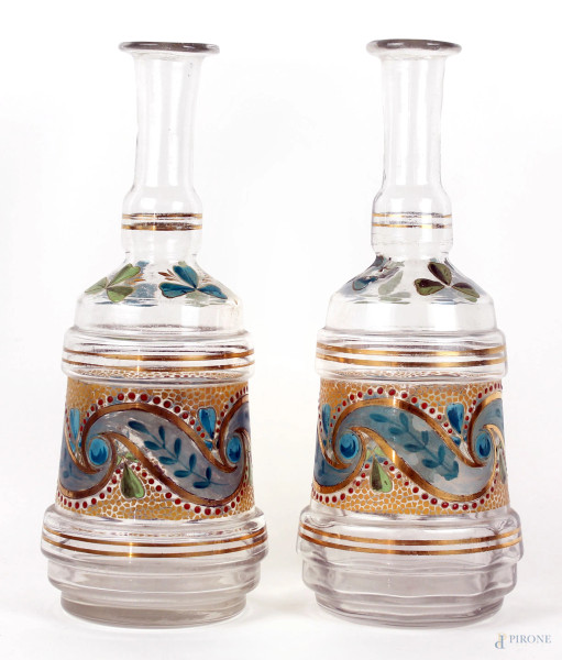 Due bottiglie in vetro con decori policromi dipinti a mano, finiture dorate, alt. cm 28,5, prima metà XX secolo.