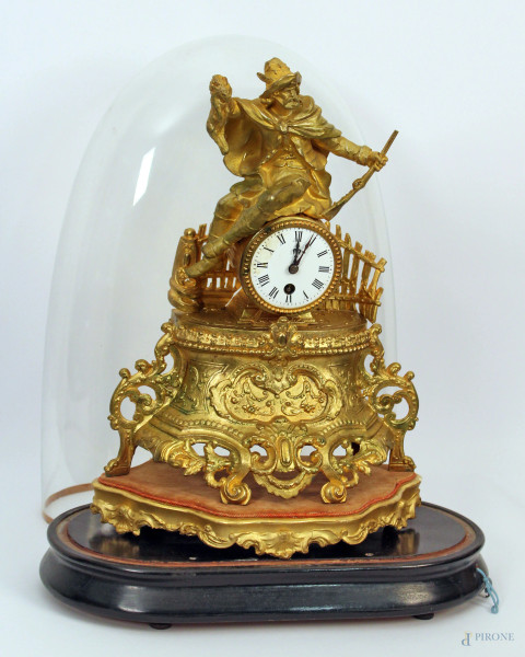 Orologio da camino in metallo dorato sormontato da cacciatore con campana in vetro, h. cm 42.