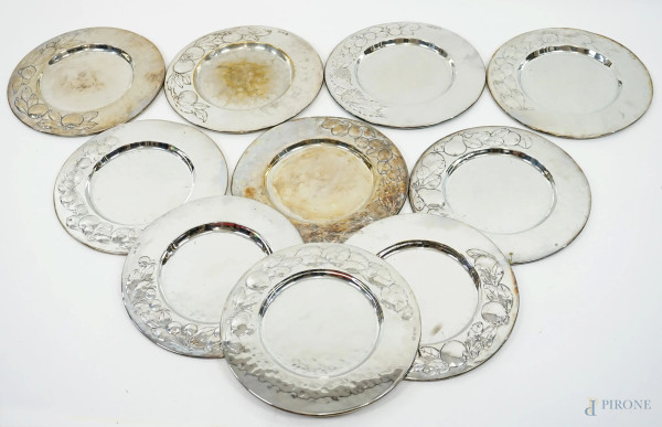 Dieci piatti in metallo argentato Brandimarte, XX secolo, tesa con decori di frutta sbalzati, diam.cm 30, (difetti).