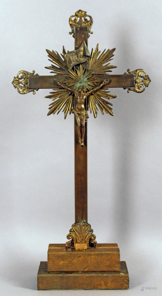 Crocifisso in metallo dorato, poggiante su base in legno, altezza 57 cm, XVIII secolo.