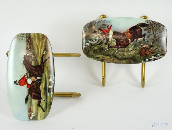 Coppia di appendiabiti in metallo e resina, decori raffiguranti scene di caccia inglesi, cm 5x14x12, XX secolo.