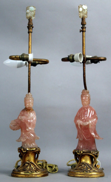 Coppia di lampade sormontate da figure in quarzo rosa, poggianti su base dorata, XX sec, h. 56 cm, (restauri).