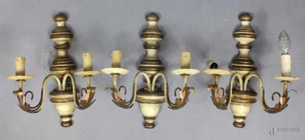 Lotto composto da tre appliques a due luci in legno e ferro, altezza 37 cm.